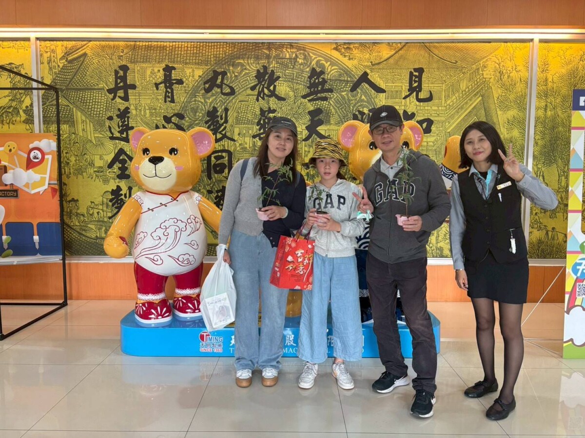 民眾參加天明製藥植樹月活動，帶著萬壽菊苗盆與「天明熊麻吉」同框合影。