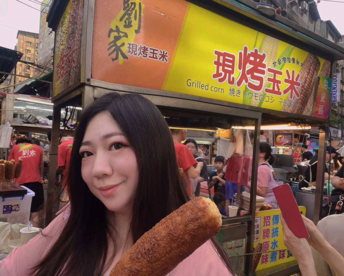 英文名師幸恩Sarinne帶路走入饒河街夜市尋找美食品嘗劉家現烤玉米。圖：臺北市市場處