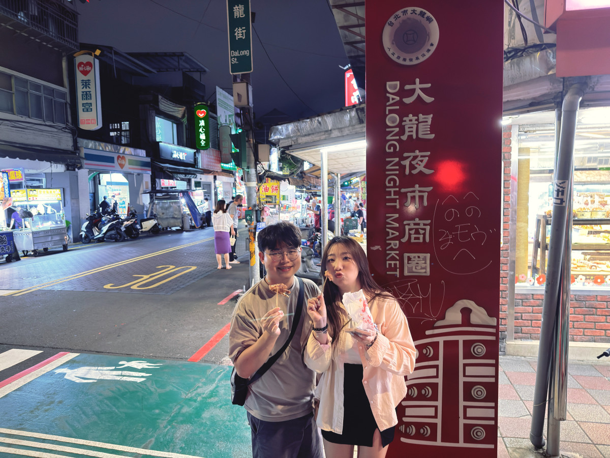 大學生創作者走訪大龍夜市,分享蔥油餅及地瓜球等經典臺灣味小吃。圖/臺北市市場處提供